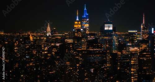 Aerial Shot of Office Buildings Late in the Evening. Rooms Have Lights On  Businesspeople and Managers Working Long Hours in New York City. Helicopter Cityscape View of Manhattan at Night