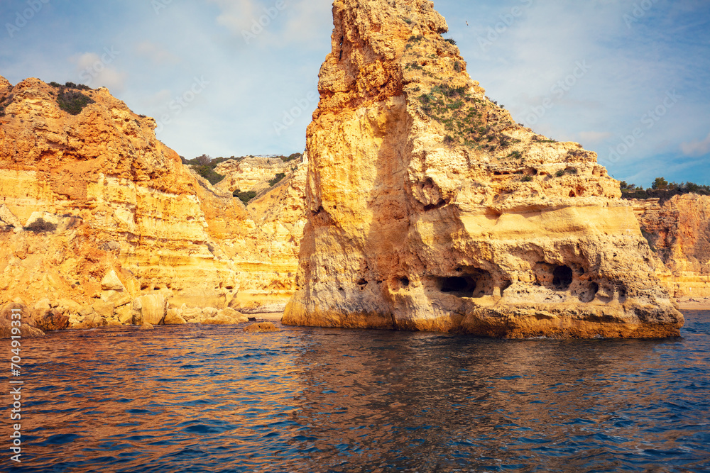 Coastal rocky seascape. Rocky shore near Praia da Marinha beach and Benagil in Algarve region in Atlantic ocean, Portugal, Europe