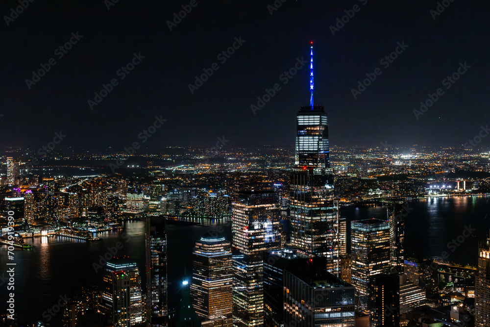 Night Aerial Shot of the One World Trade Center Skyscraper with Antenna. Helicopter Photo of a Group of Glass Buildings in Manhattan