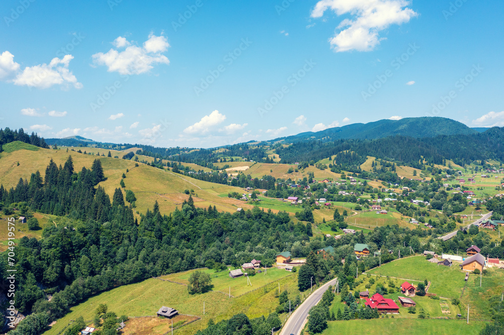 Aerial view of the mountains and village in the valley in spring. Beautiful nature landscape. Carpathian mountains. Ukraine