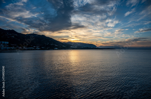 Sunset from the docks over the sea and mountains of the village of Cefalu  Italy