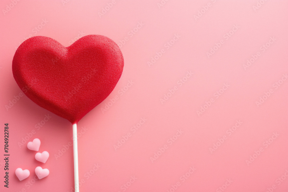 Red heart on stick on pink background. Top view with copy space.
