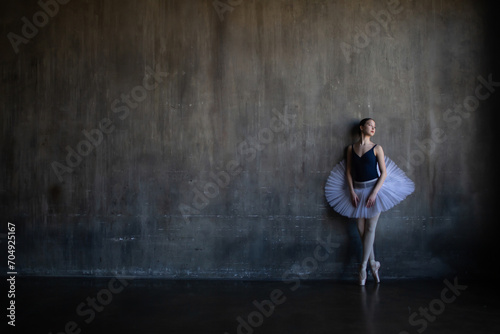 Ballerina stands near the wall