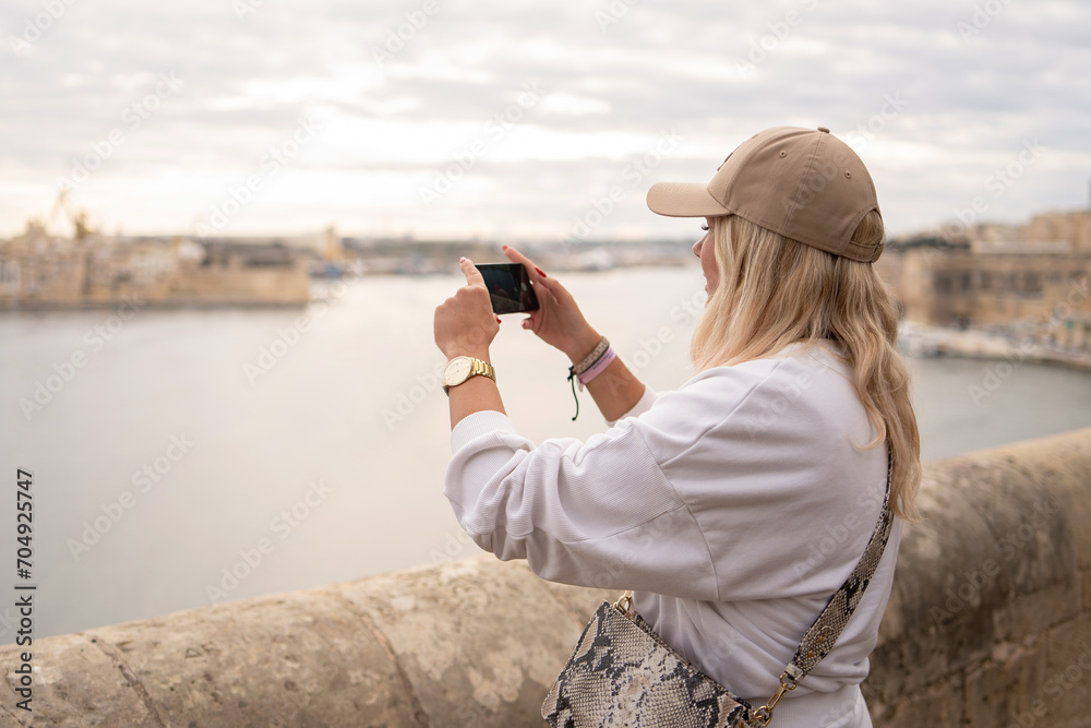 Girl taking photo of Malta Island bay