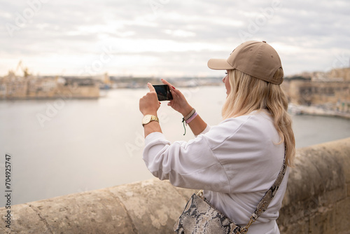Girl taking photo of Malta Island bay