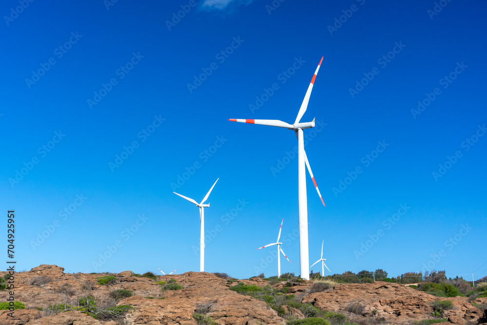 Wind turbine in mountains landscape. Eolic park windpower. Wind farm or New Wind green energy. Wind turbines alternative energy. Windmill power clean electricity generation in Sardinia, Italy Wind turbine in mountains landscape. Eolic park windpower. Wind farm or New Wind green energy. Wind turbines alternative energy. Windmill power clean electricity generation in Sardinia, Italy