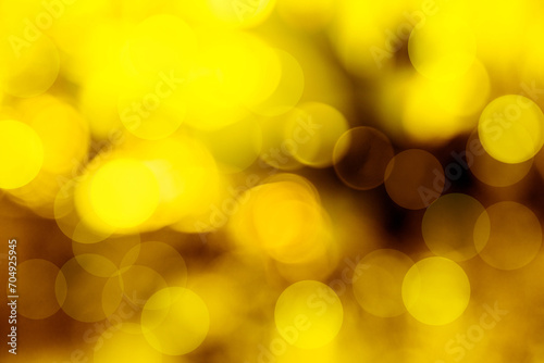 A golden flare and a shimmering golden bokeh flare against a dark background serve as the background... © unairakstudio
