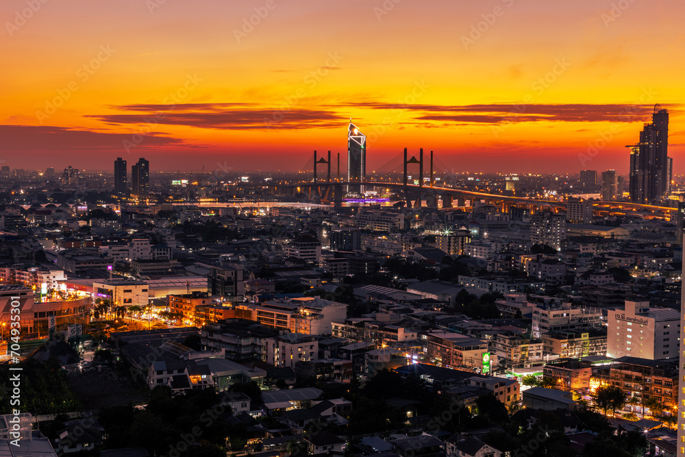 Obraz premium The high angle background of the city view with the secret light of the evening, blurring of night lights, showing the distribution of condominiums, dense homes in the capital community