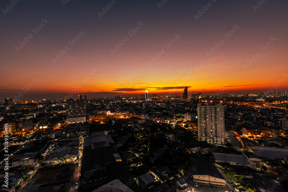 The high angle background of the city view with the secret light of the evening, blurring of night lights, showing the distribution of condominiums, dense homes in the capital community