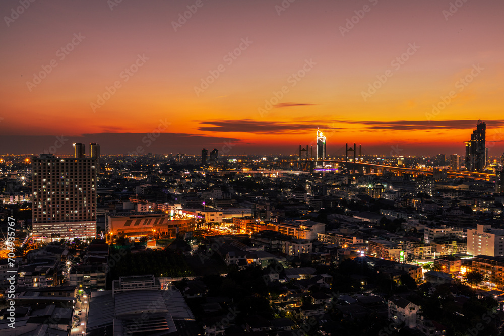 The high angle background of the city view with the secret light of the evening, blurring of night lights, showing the distribution of condominiums, dense homes in the capital community