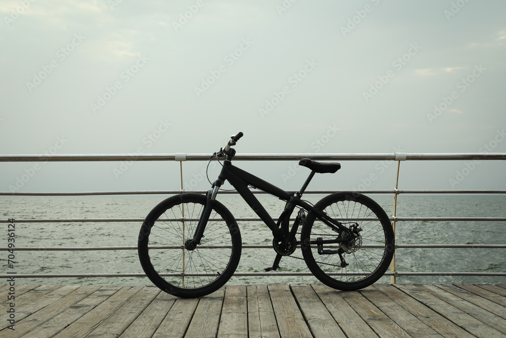 Black bicycle on wooden floor outdoors by the sea Black bicycle on wooden floor outdoors by the sea