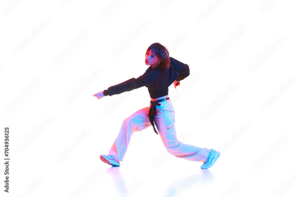 Young woman dancing hip hop, breakdance, dance hall isolated over white background in neon light. Concept of contemporary dance, street style, youth, hobby, action, lifestyle Young woman dancing hip hop, breakdance, dance hall isolated over white background in neon light. Concept of contemporary dance, street style, youth, hobby, action, lifestyle