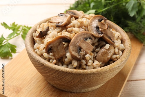 Delicious pearl barley with mushrooms on table, closeup