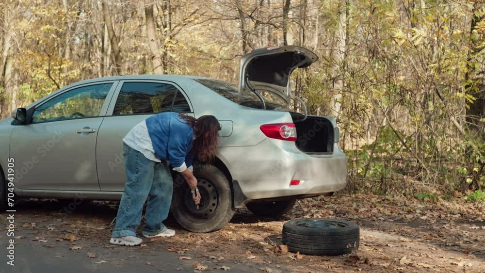 On-the-Go Repairs: Woman Changing Flat Tire, Roadside Breakdown Adventure. High quality 4k footage