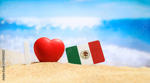 I love Mexico. Flag of Mexico on the beach with a red heart. vacation and travel concept.