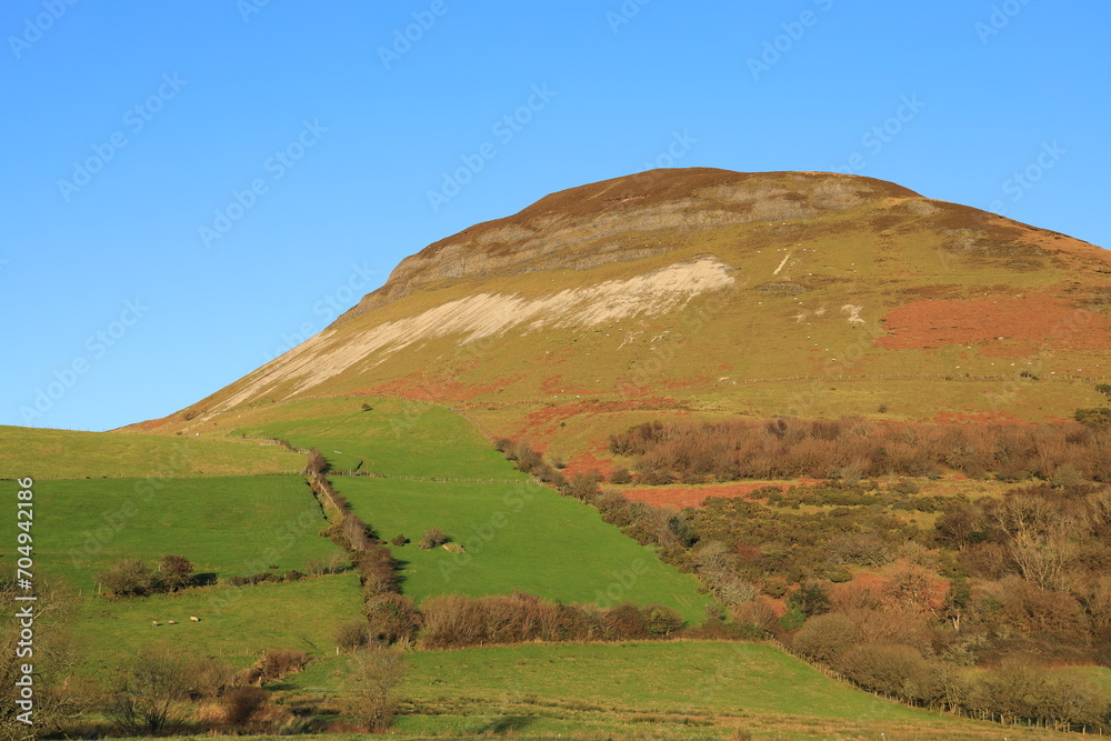 Obraz premium Landscape at Keelogyboy Mountain, County Sligo, Ireland on winter day featuring colourful vegetation against backdrop of blue sky