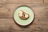 Toast with tasty nut butter, banana slices and peanuts on wooden table, top view