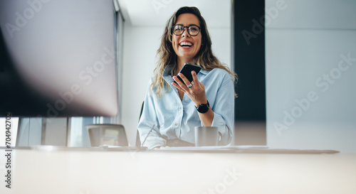 Happy business woman having a phone call with her associates photo