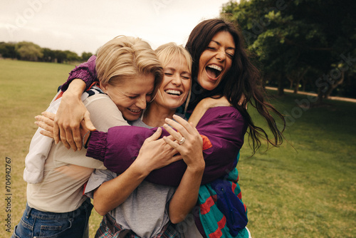 Friends hugging each other in park, sharing laughter and love outdoors photo