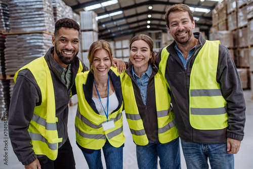 Full team of warehouse employees standing in warehouse. Team of workers in reflective clothing in modern industrial factory, heavy industry, manufactrury. photo