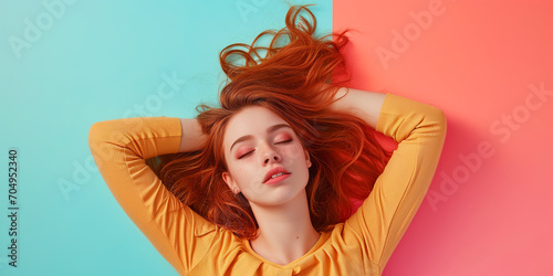 Junge Frau liegt auf pastellfarbenem Untergrund und entspannt