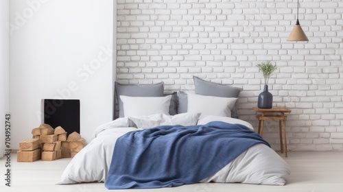 blue pillows and a coverlet is placed near a fireplace against a white brick wall, showcasing the modern, Scandinavian interior design of a loft bedroom. photo