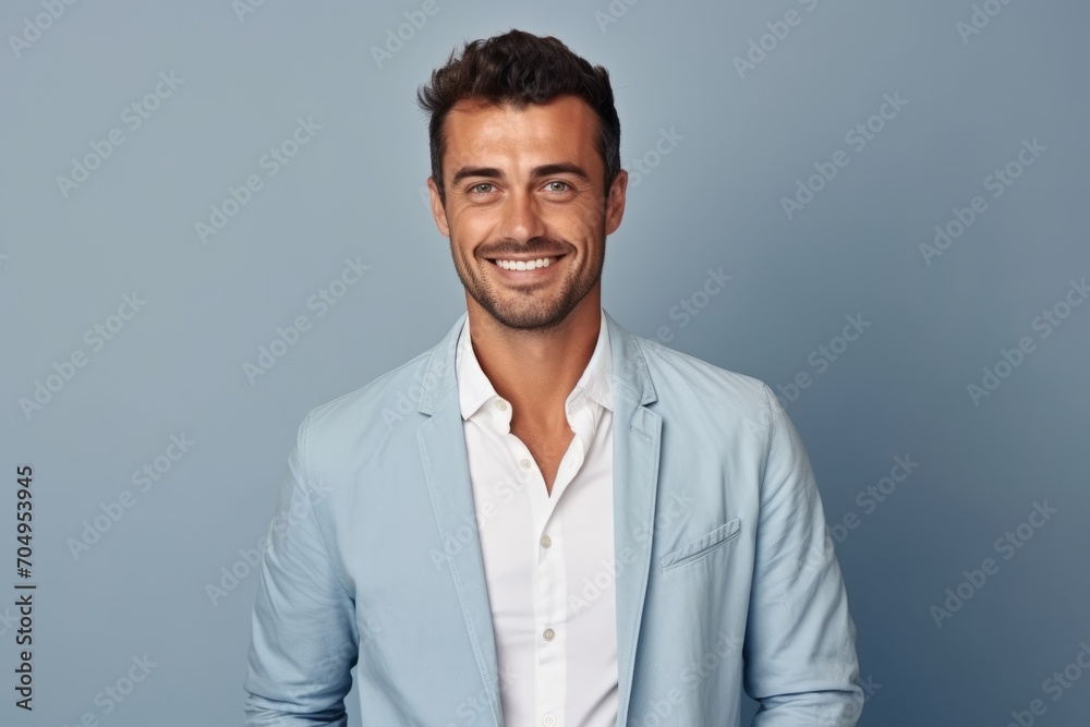 Portrait of handsome young man in casual wear smiling at camera while standing against grey background Portrait of handsome young man in casual wear smiling at camera while standing against grey background