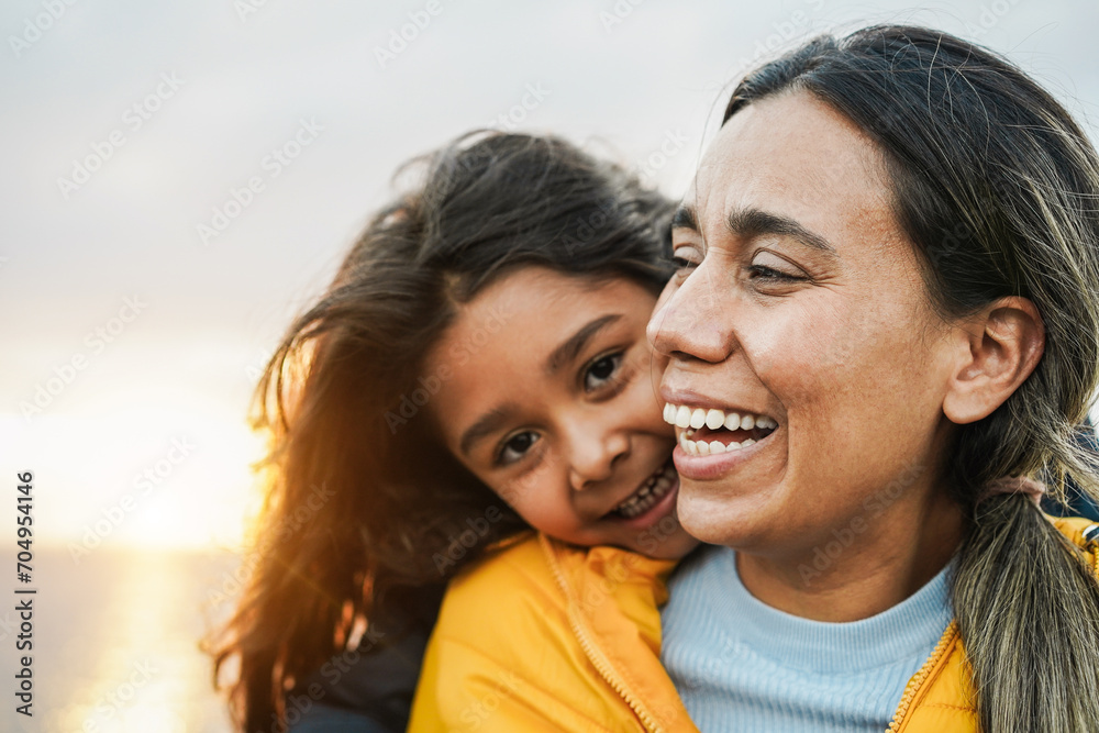 Happy latin mother and daughter having fun together during winter time - Mom day concept - Focus on mum face Happy latin mother and daughter having fun together during winter time - Mom day concept - Focus on mum face