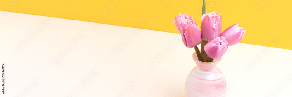 Φωτογραφία Banner with bouquet of pink tulip flowers in front of yellow background