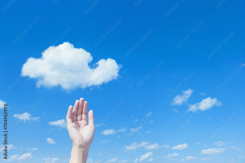 a hand in front of beautiful blue sky with white cumulus clouds for abstract background