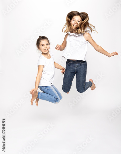 zwei Mädchen im Studio Portrait Sprung mit fliegenden Haaren photo