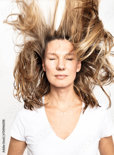 Studio Portrait Frau mit geschlossenen Augen und fliegenden Haaren