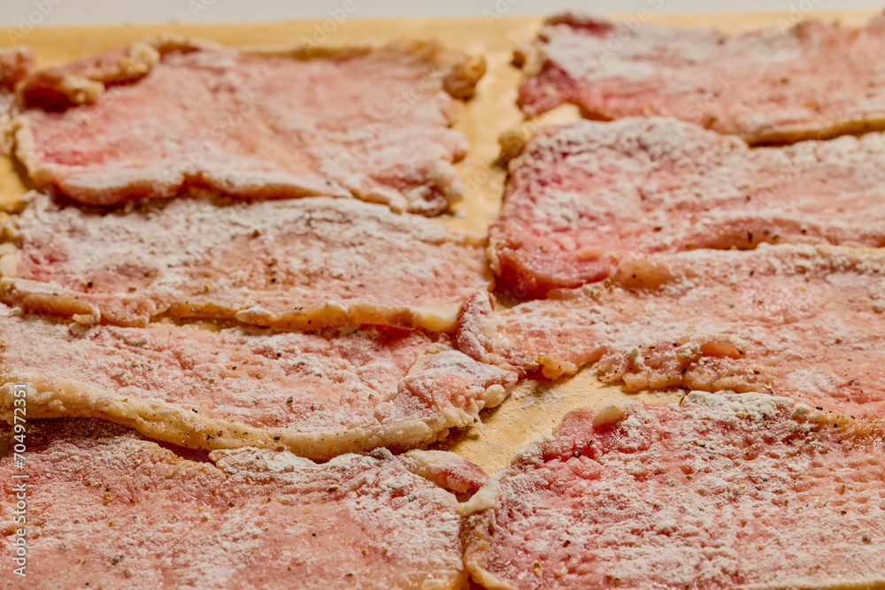 Pork tenderloin thinly sliced and prepared for schnitzel before cooking. Pork tenderloin thinly sliced and prepared for schnitzel before cooking.