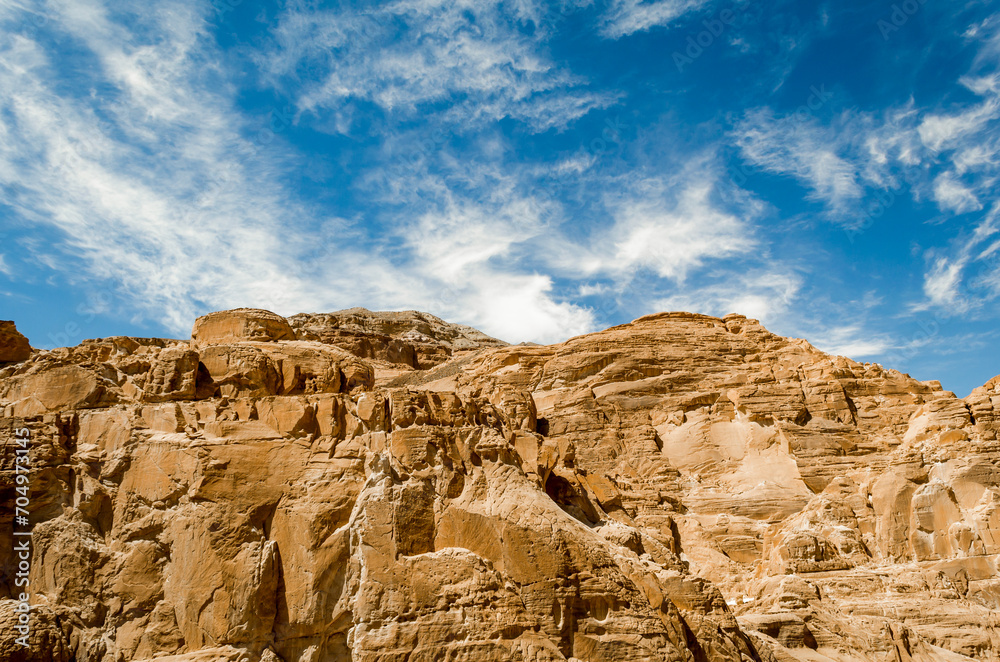 high rocky mountains in the desert against the blue sky and white clouds in Egypt Dahab South Sinai high rocky mountains in the desert against the blue sky and white clouds in Egypt Dahab South Sinai