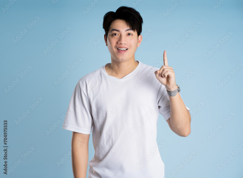 Portrait of Asian guy posing on blue background Portrait of Asian guy posing on blue background