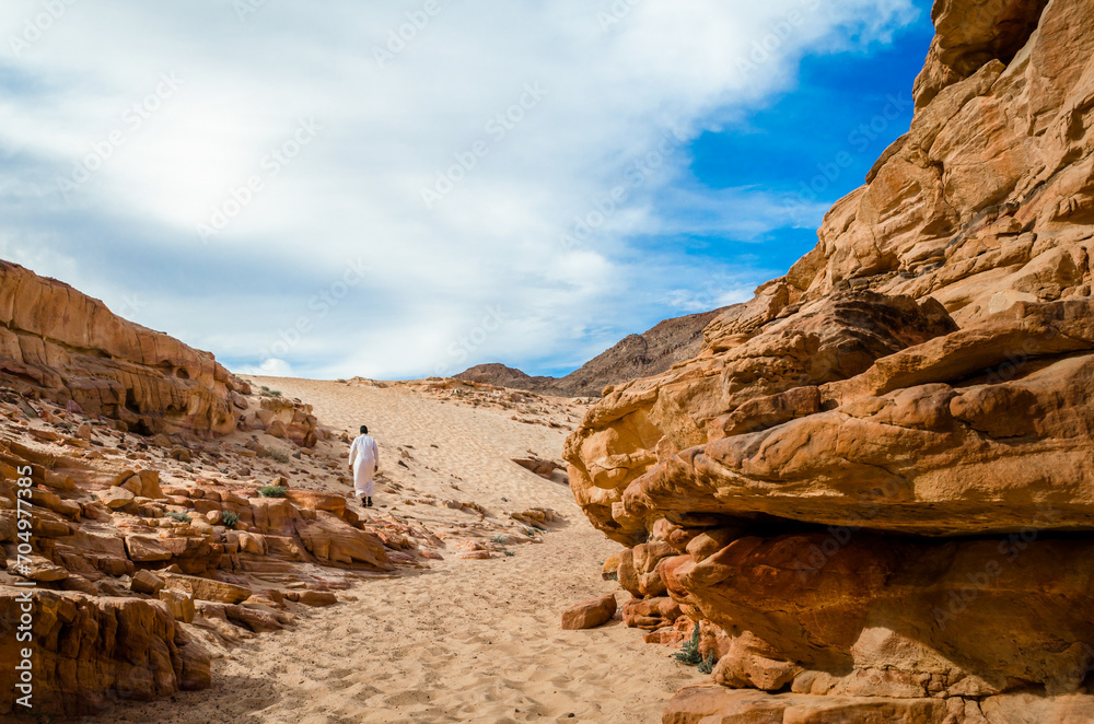 Fototapeta premium man in white arab clothing walks in a colored canyon in Egypt Dahab South Sinai