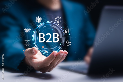 B2B marketing concept, business to business, e-commerce, businessman use laptop with virtual B2B icons for professional business and commerce collaboration. business action plan strategy.
