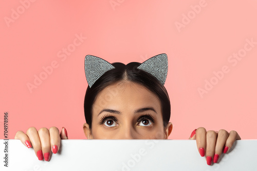 Fotografi Beautiful brunette wearing cat ears glamour hoop on pink background