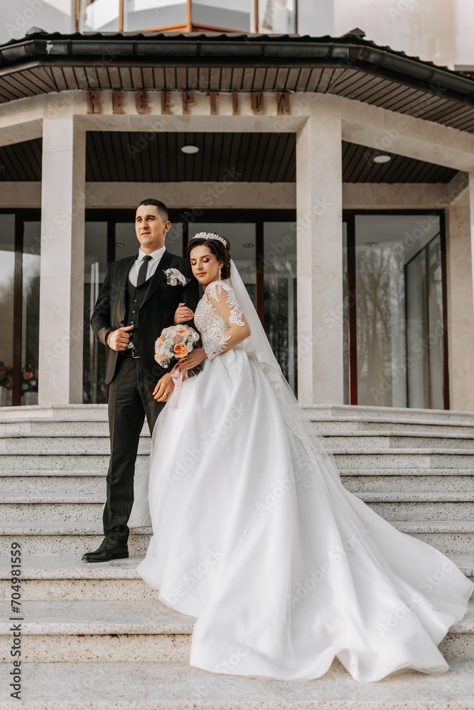 Wedding couple in love. A beautiful bride and an elegant groom tenderly embrace and enjoy the day. A stylish couple of newlyweds. Concept of marriage Wedding couple in love. A beautiful bride and an elegant groom tenderly embrace and enjoy the day. A stylish couple of newlyweds. Concept of marriage