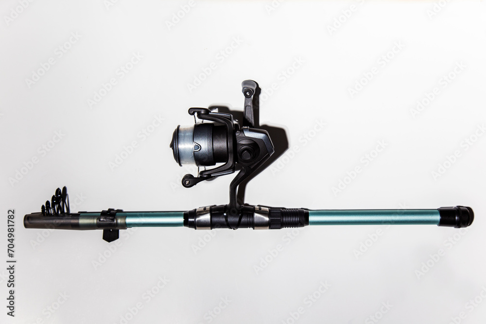 close-up of fishing reel with fishing rod on a white background isolated. Top view. Copy space. close-up of fishing reel with fishing rod on a white background isolated. Top view. Copy space.