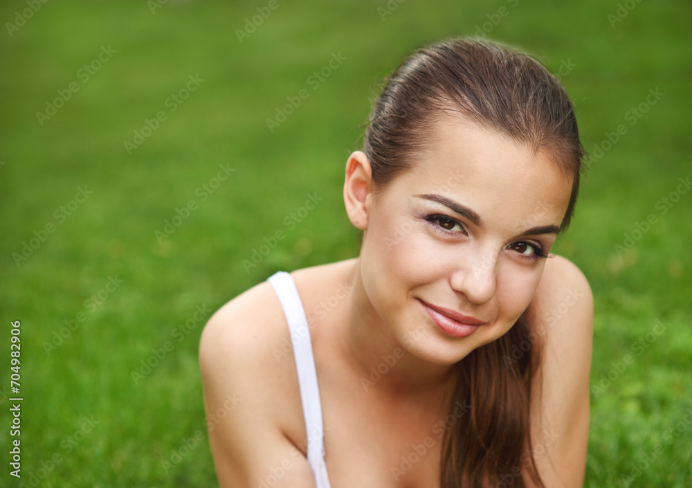 Beautiful young girl lying in summer park