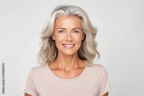 beauty, people and health concept - smiling senior woman over grey background © Inigo