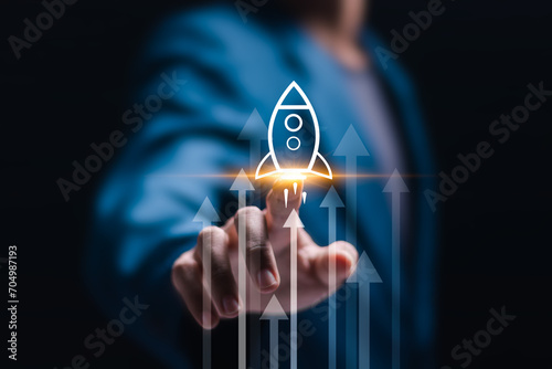 Billede på lærred Startup business concept, Businessman touch virtual rocket icon and up arrow for fast start up business