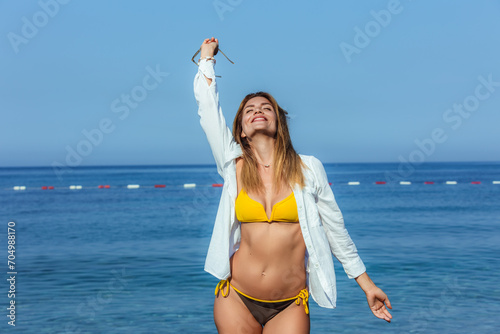 Young beautiful woman walking by the sea.