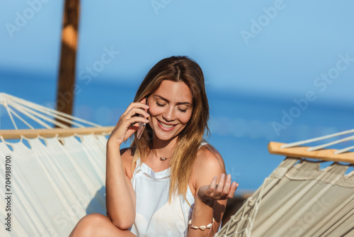 Young beautiful woman talking on the phone on the beach. © Mediteraneo