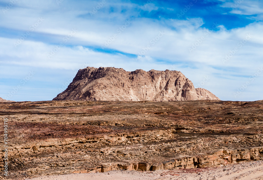 high mountain in the desert against the blue sky and white clouds in Egypt Dahab South Sinai high mountain in the desert against the blue sky and white clouds in Egypt Dahab South Sinai