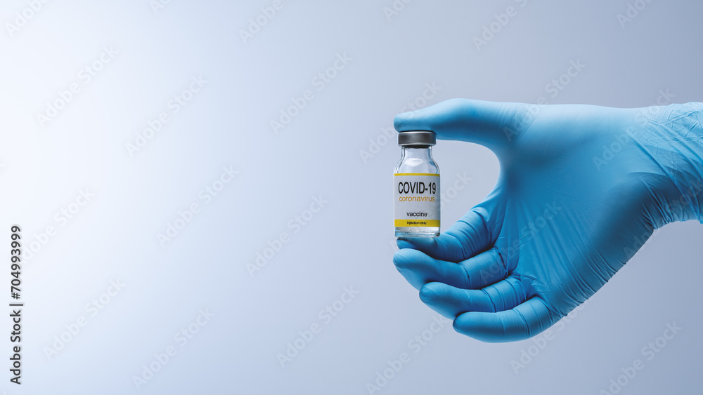 Doctor in blue latex gloves holding glass vial with medicine. Vaccination, immunization, treatment to Covid 19 Corona Virus infection. Healthcare And Medical concept. Doctor in blue latex gloves holding glass vial with medicine. Vaccination, immunization, treatment to Covid 19 Corona Virus infection. Healthcare And Medical concept.