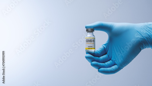 Doctor in blue latex gloves holding glass vial with medicine. Vaccination, immunization, treatment to Covid 19 Corona Virus infection. Healthcare And Medical concept.