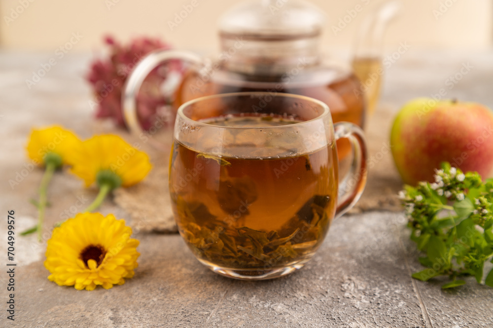 Red tea with herbs in glass teapot on brown concrete. Side view, selective focus. Red tea with herbs in glass teapot on brown concrete. Side view, selective focus.