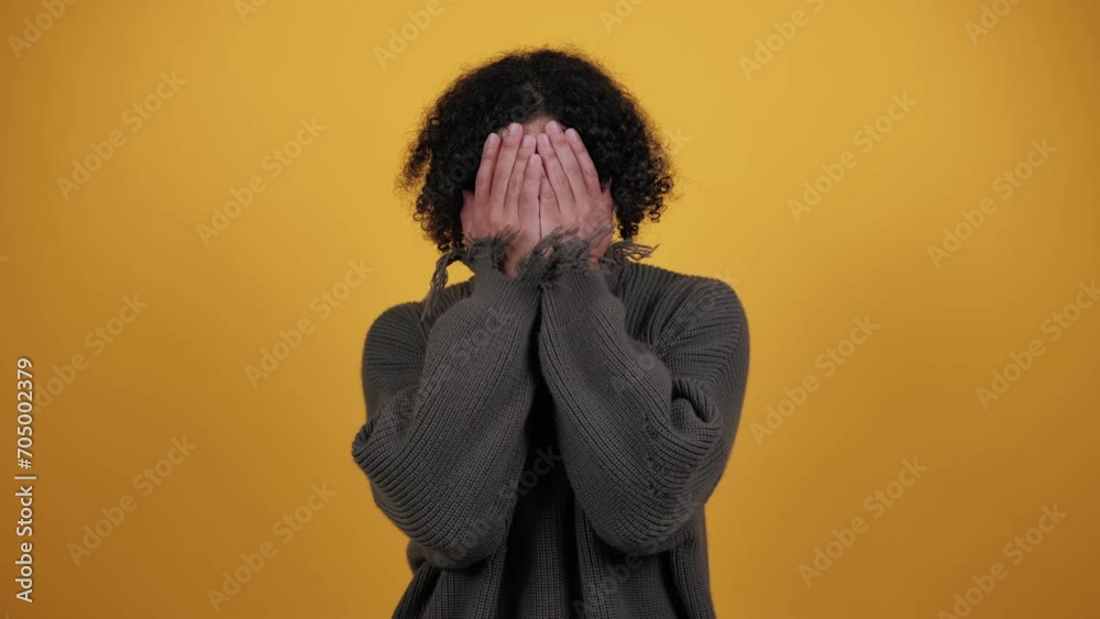 Shocked man, covers face with hands, look from fingers, isolated on yellow studio background, free space. Problems, stress, fear emotions, scared film, facial expression Shocked man, covers face with hands, look from fingers, isolated on yellow studio background, free space. Problems, stress, fear emotions, scared film, facial expression